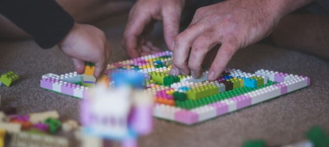 Parent and kid with blocks.