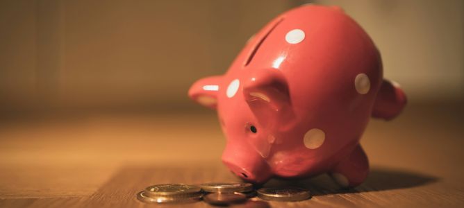 Piggy bank tipped over spilling loonies and toonies. Piggy bank tipped over spilling loonies and toonies.