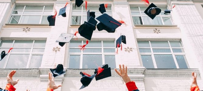 Graduates throwing graduation caps in the air.