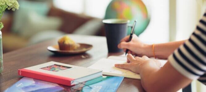 Woman writing next to books. Woman writing next to books.