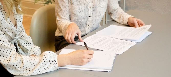 Women at work looking at papers. Women at work looking at papers.